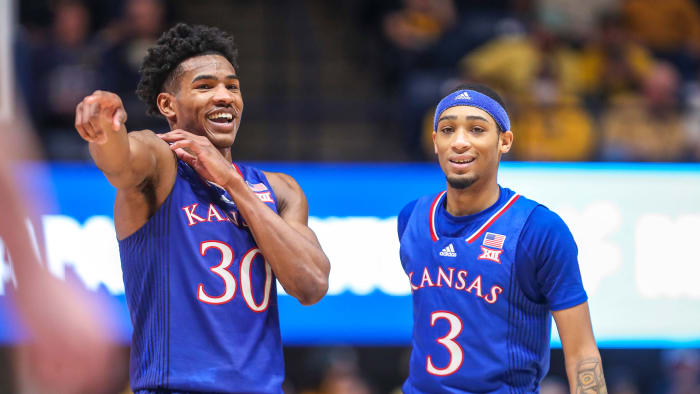 Kansas’s Ochai Agbaji (30) talks with guard Dajuan Harris Jr.